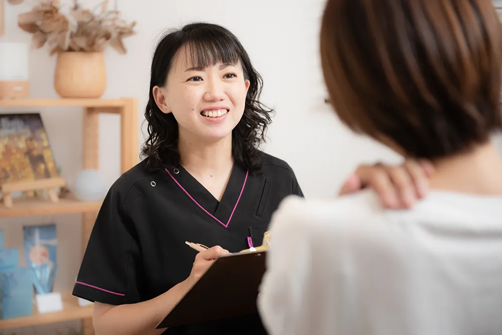 女性のカウンセリングを行う整体師
